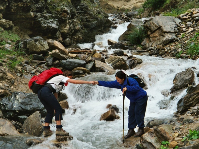 Deux trekkeurs traversant une rivière